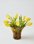 Brown colored spotted vase with yellow tulips on a white background