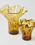 Two amber-colored glass vases with wavy designs on a white background
