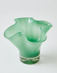 Green glass vase with wavy design on a white background