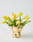Gold vase with yellow tulips on a light gray background