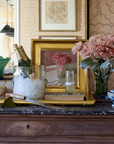 Decorative setting with champagne, ice, vase, and flowers on a table.