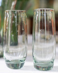 A pair of clear stemless champagne glasses with hand-etched stars on them, displayed on a table.