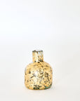 A small handmade glass vase with gold leaf patterns, displayed against a neutral background.