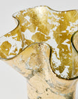 Close up view of a 14k gold covered textured vase on a white background