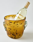 Wine bottle in a decorative amber ice bucket on a light gray background