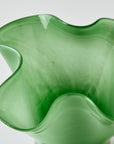 Green glass vase with wavy design on a white background