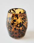 Amber colored stemless wine glass with tortoise design on a white background
