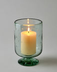Candle in a clear starry candleholder on a gray background