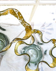 Clear glass vase with a wavy design with the rim covered in 14k gold leaf