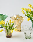 Collection of glass vases with yellow tulips on a white background