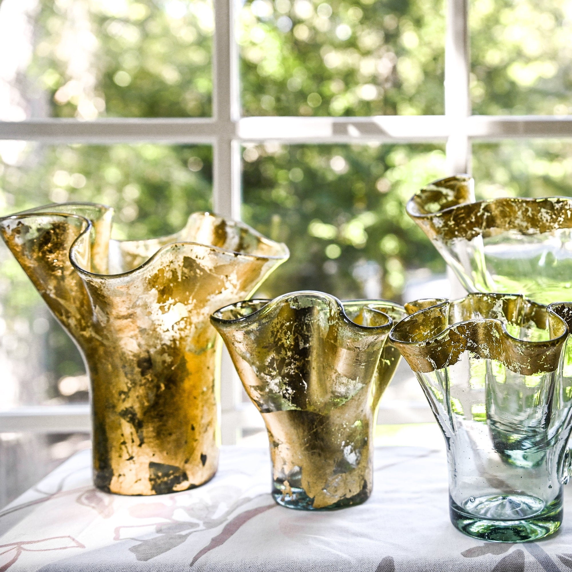 Four glass vases with two fully covered in 14k gold leaf, and the other covered only in the rim, in various sizes