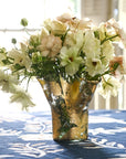 A clear glass vase covered in hand-applied 14k gold leaf with flowers