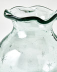 Clear starry glass vase with wavy rim on a white background