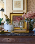 Decorative setting with a bottle of champagne, glasses, and flowers on a marble surface.