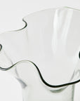Clear glass pitcher with wavy design on a white background
