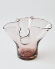 Pink glass vase with a lettuce leaf design on a white background