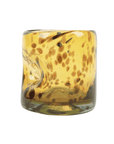 Brown spotted glass with a thumbprint indent on a white background