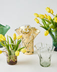 Collection of glass vases with yellow tulips on a white background