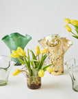 Collection of glass vases with yellow tulips on a white background
