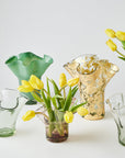Collection of glass vases with yellow tulips on a white background