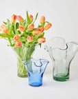 Three glass vases with a bouquet of tulips on a white background