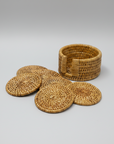 Set of woven rattan coasters and a matching basket on a white background