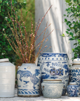 Collection of blue and white ceramic pots with intricate designs outdoors.