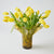 Yellow tulips in a decorative glass vase on a light background