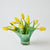 Green vase with yellow tulips on a white background