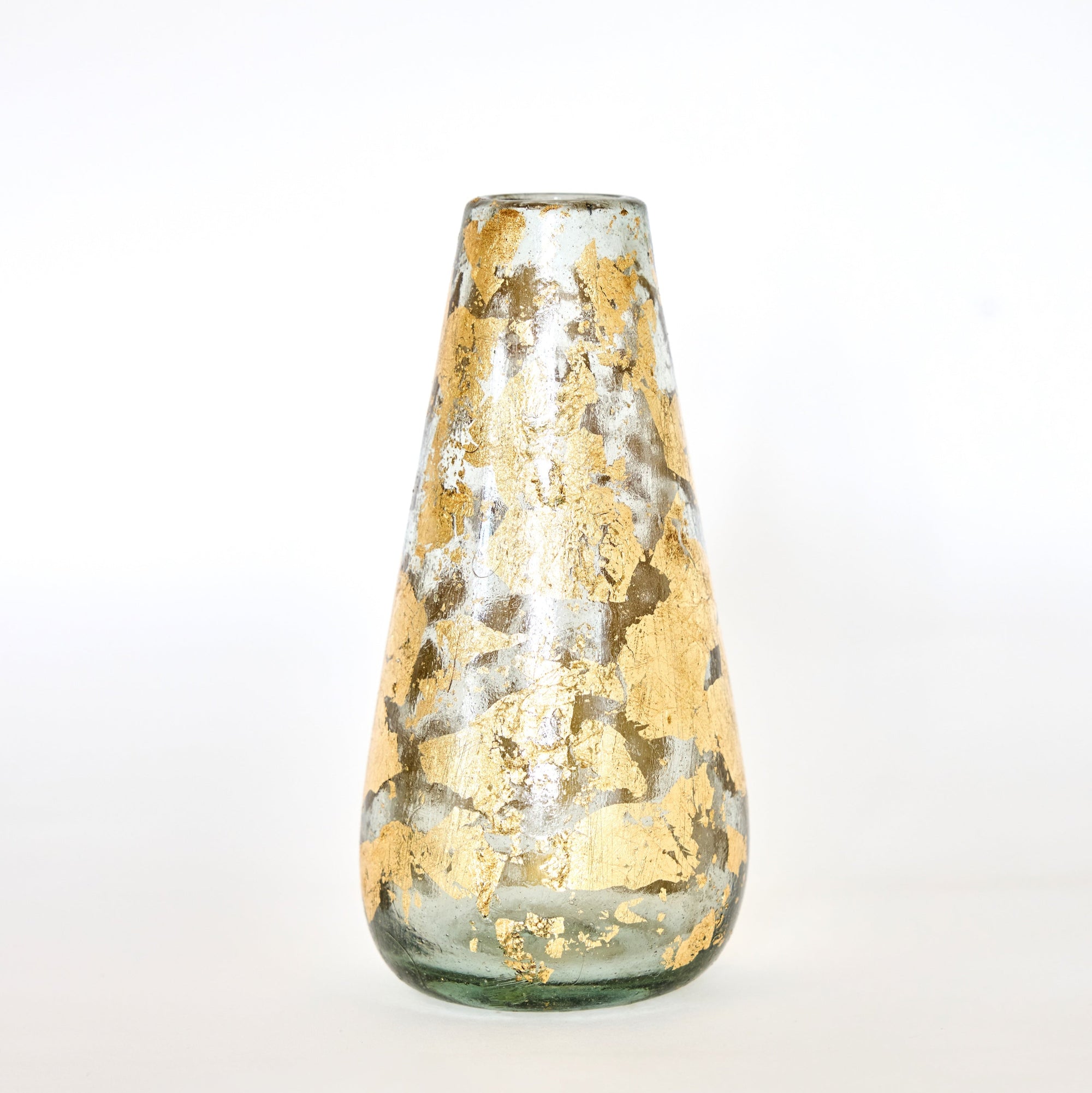 A hand-blown glass vase with 14k gold leaf detailing, with a focus on the texture and shine of the gold against the clear glass.
