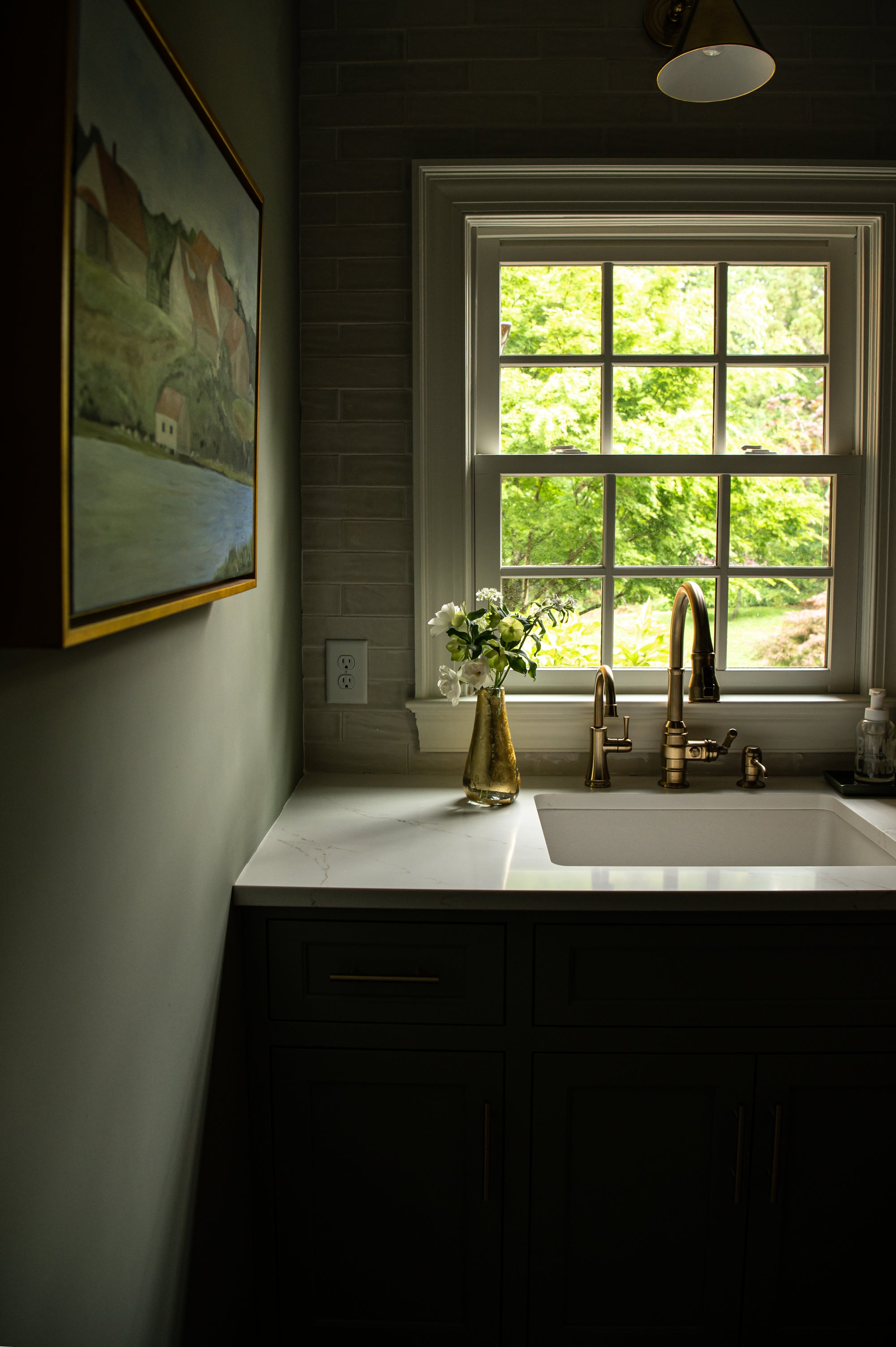 Tall vase with 14k hand-applied gold leaf sitting on a sink
