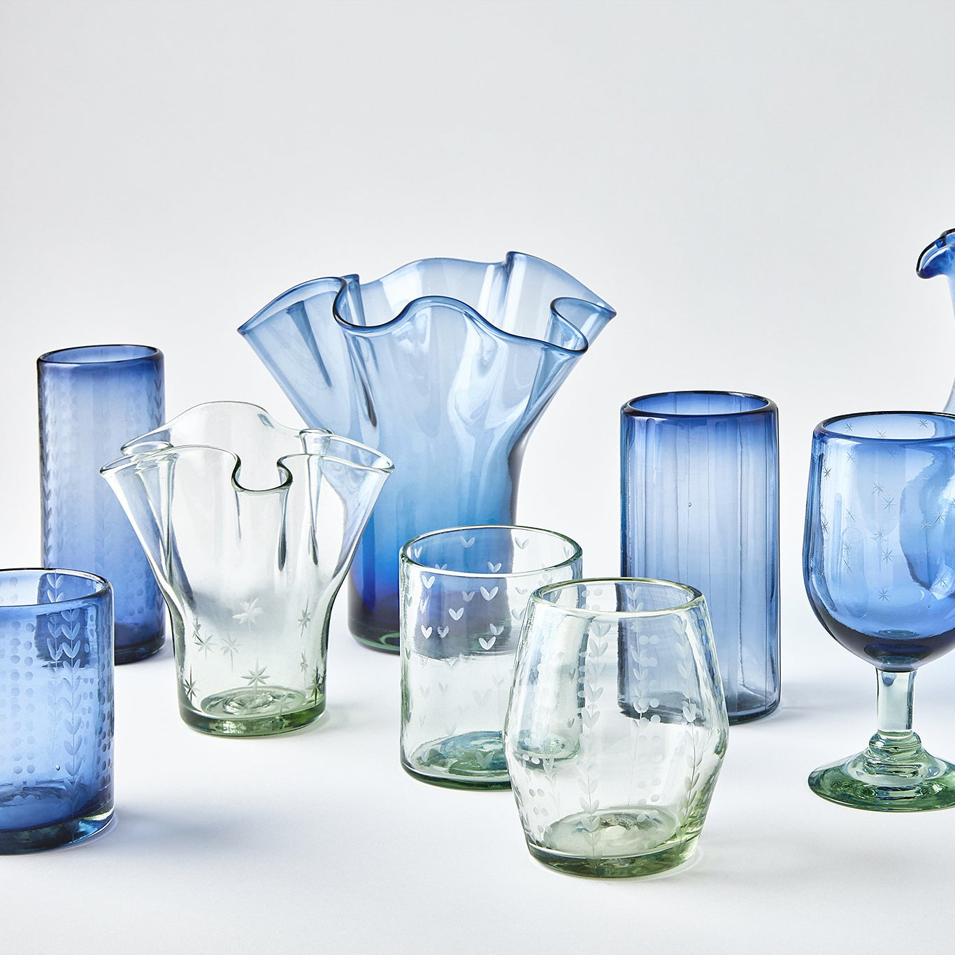 Collection of blue and clear glassware on a white background