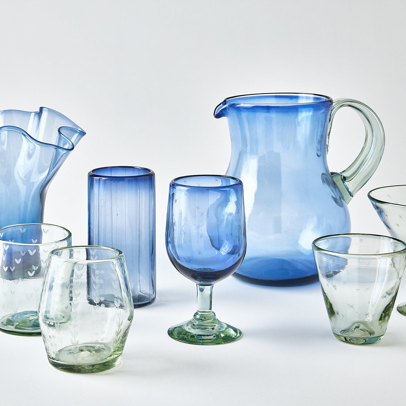 Collection of blue and clear glassware on a white background