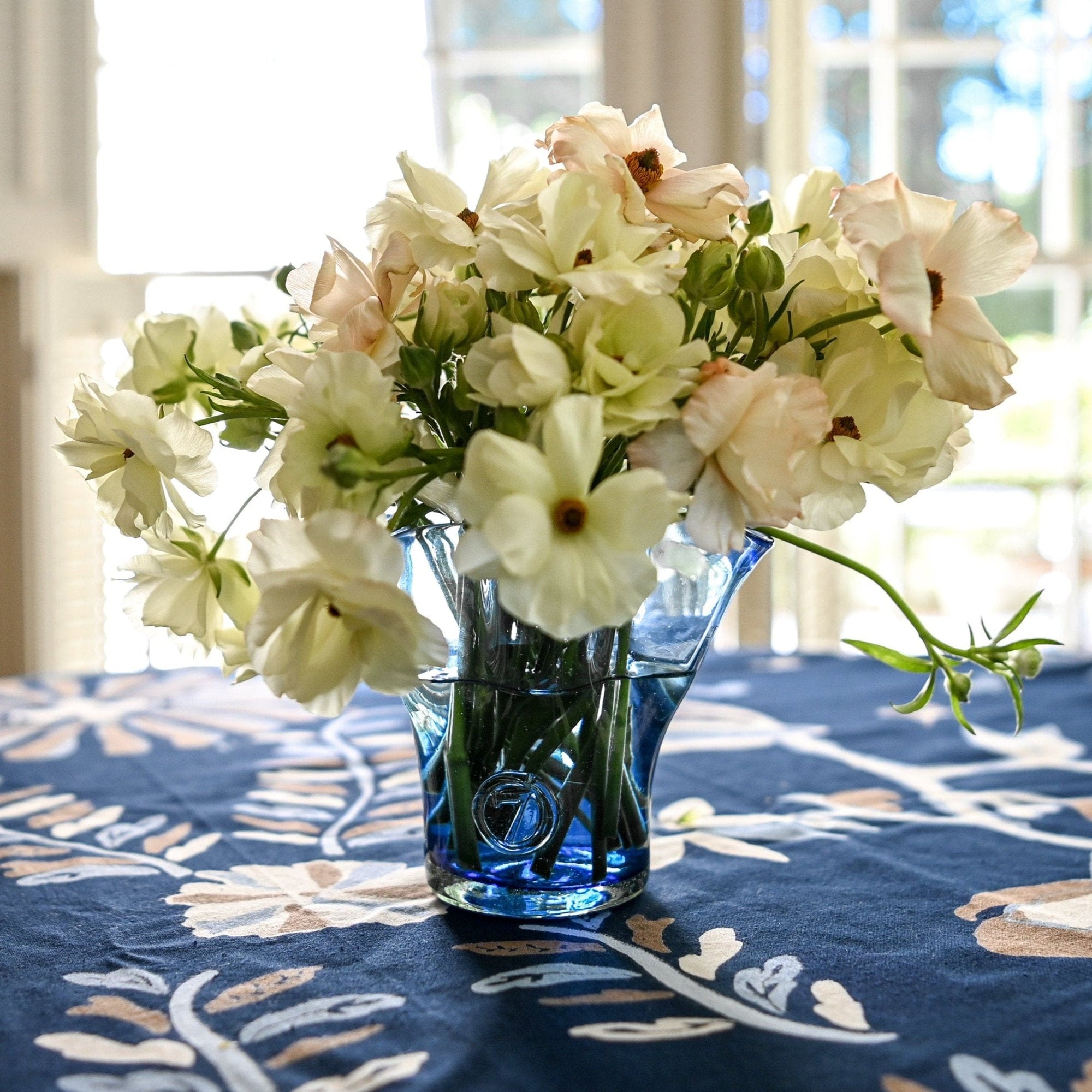 Blue glass vase with a wavy pattern with flowers