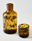 Two tortoiseshell-patterned glass vessels on a white background