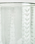 Clear glass vase with a dot and fern pattern on a white background