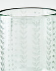 Close up shot of a clear glass candleholder with decorative etching on a white background