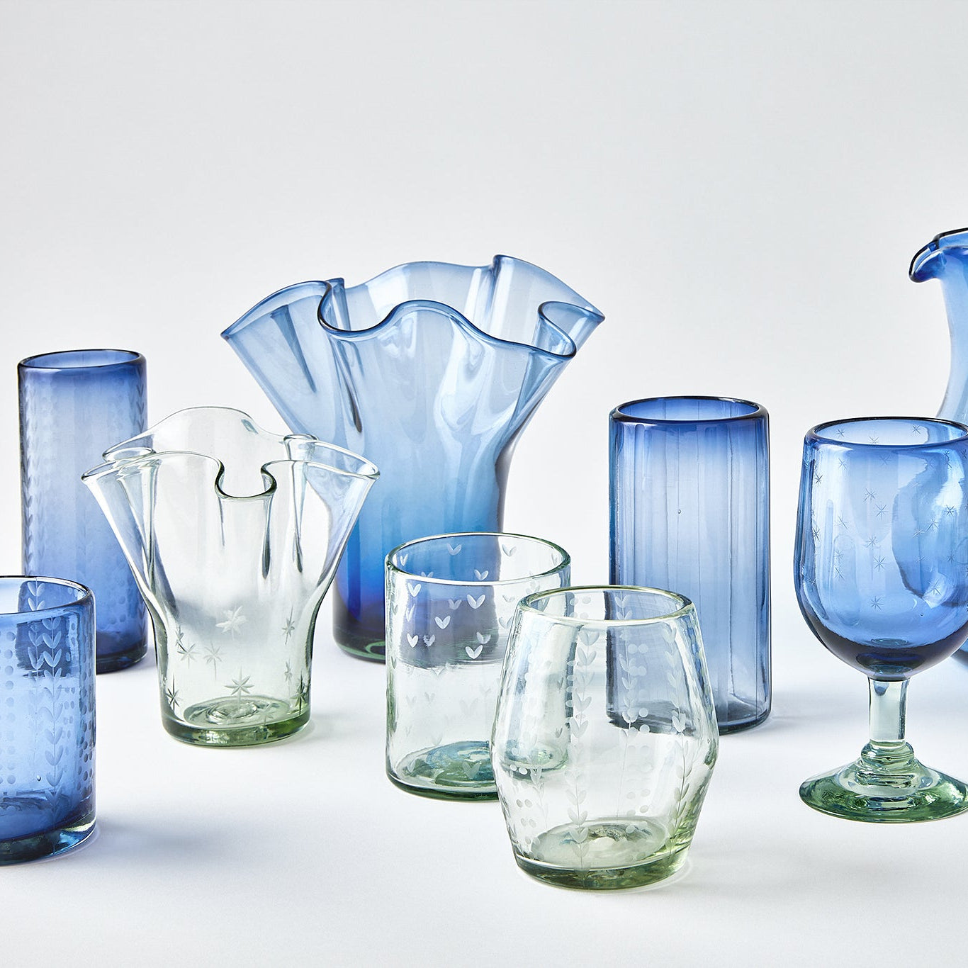 Collection of blue and clear glassware on a white background