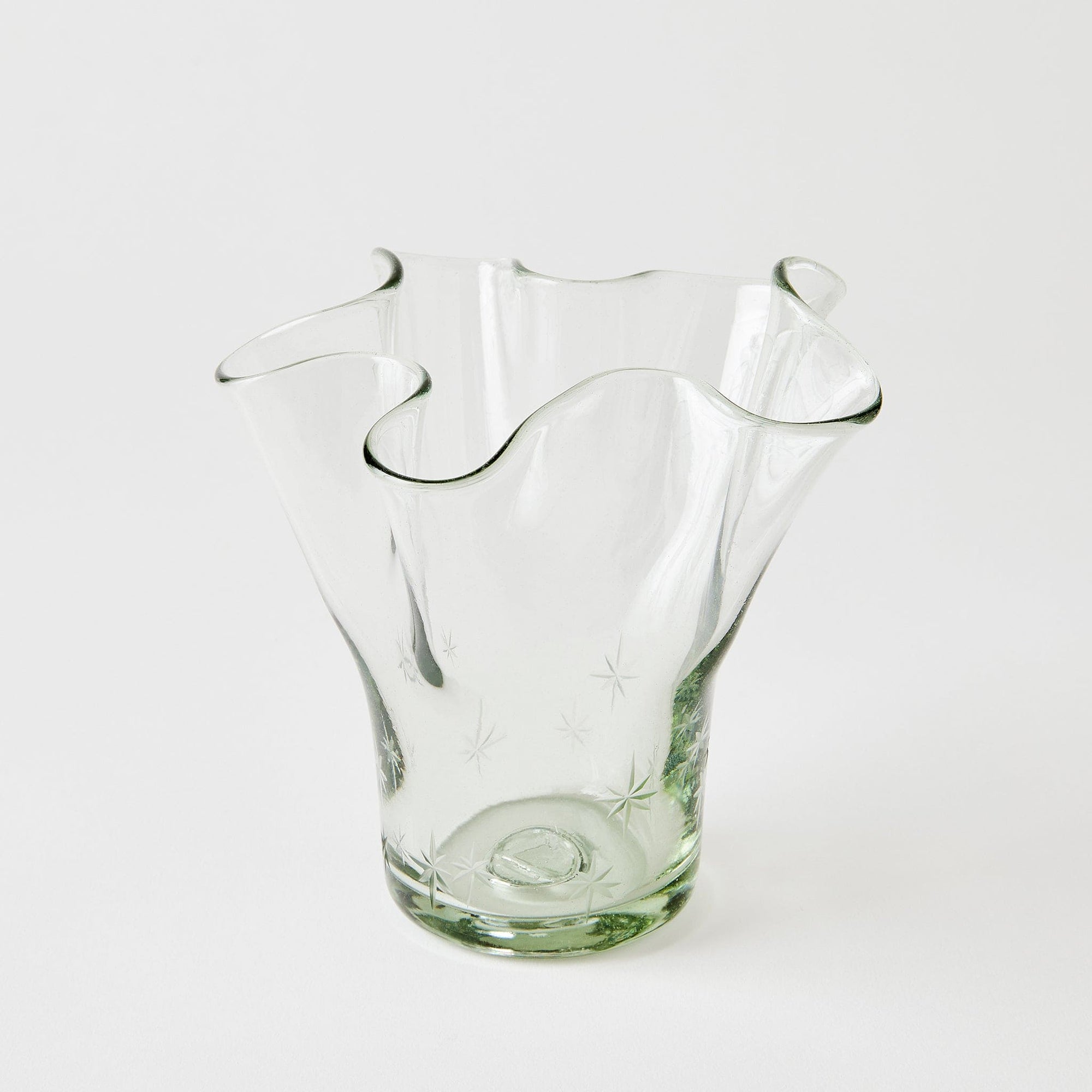Clear glass vase with wavy design on a white background