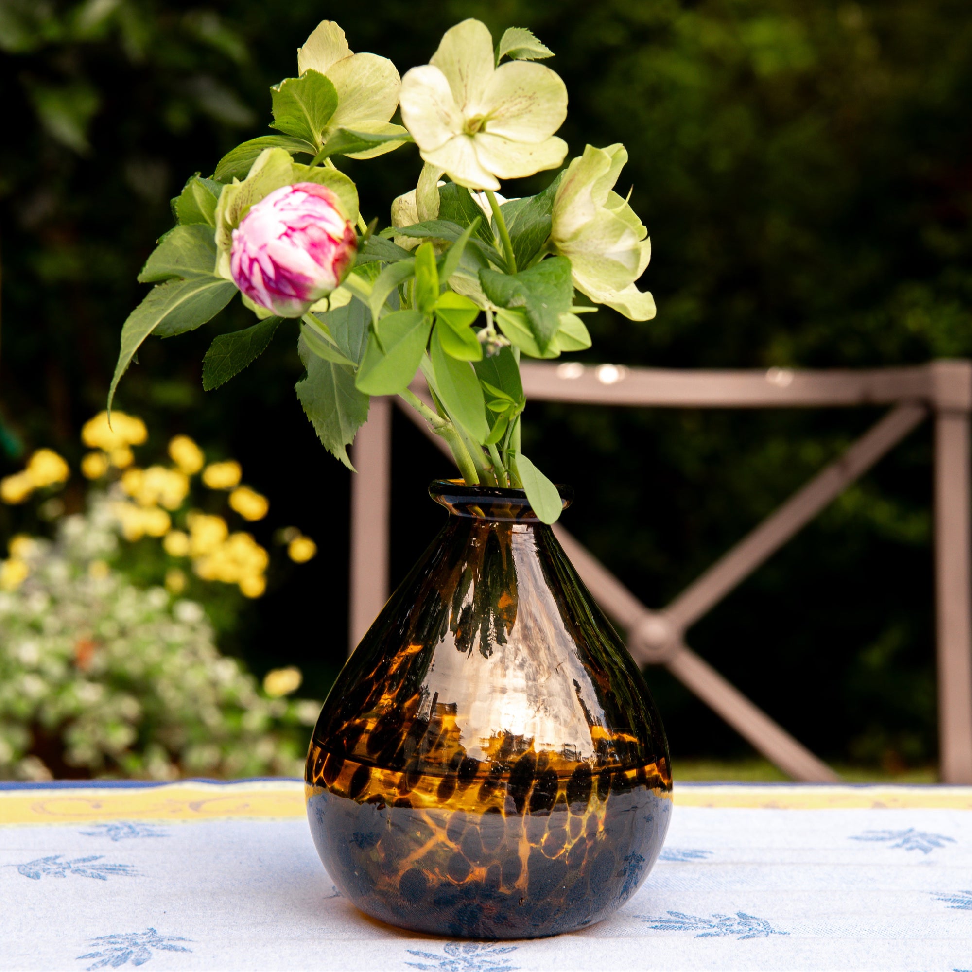 Decorative vase with flowers on a table outdoors