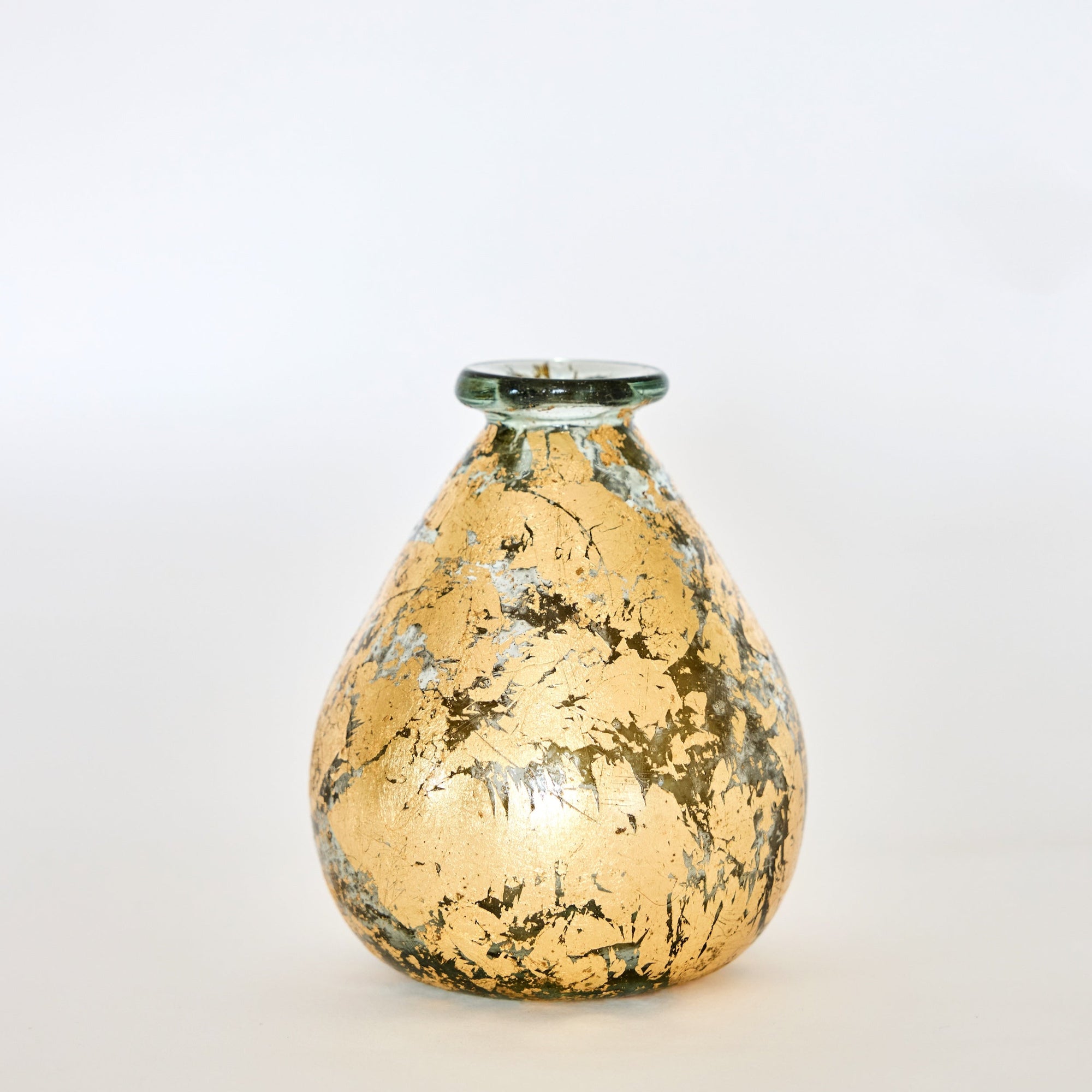 A hand-blown, gold leaf decorative glass vase with a teardrop shape on a white background.