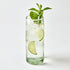 Glass of water with lime slices and mint leaves on a white background