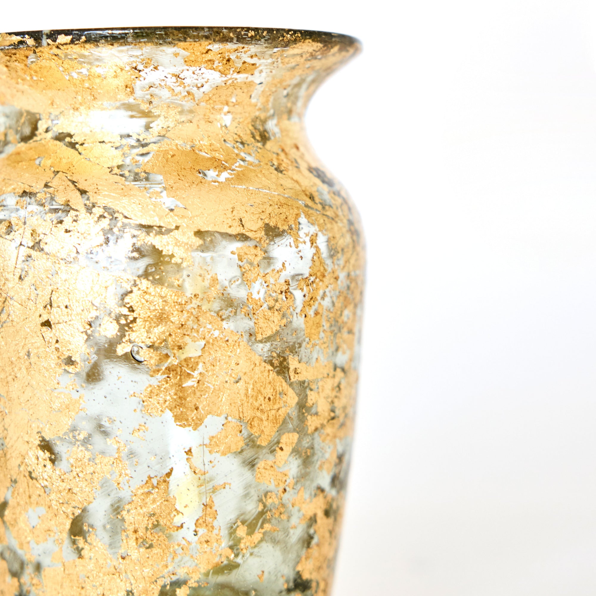 Glass vase with gold leaf on a white background