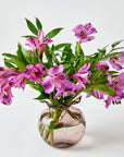 Bouquet of pink flowers in a pink starry vase on a light background