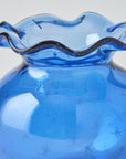 Blue glass vase with wavy rim on a white background
