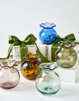 Set of colorful glass vases with green ribbons on a white background