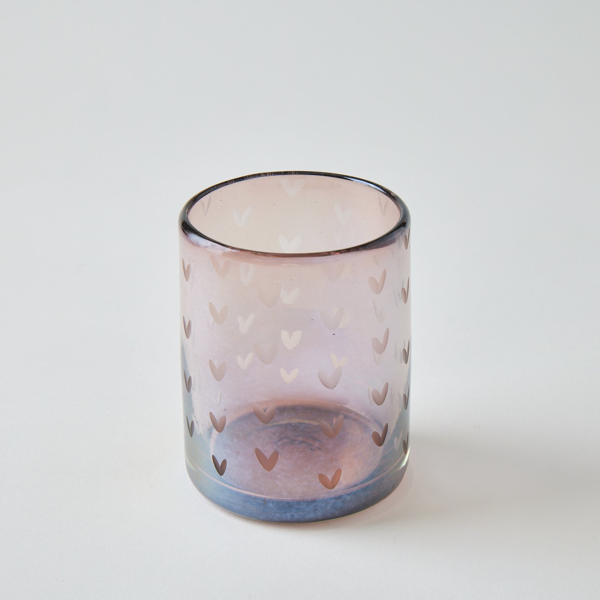 Glass candle holder with heart pattern on a white background