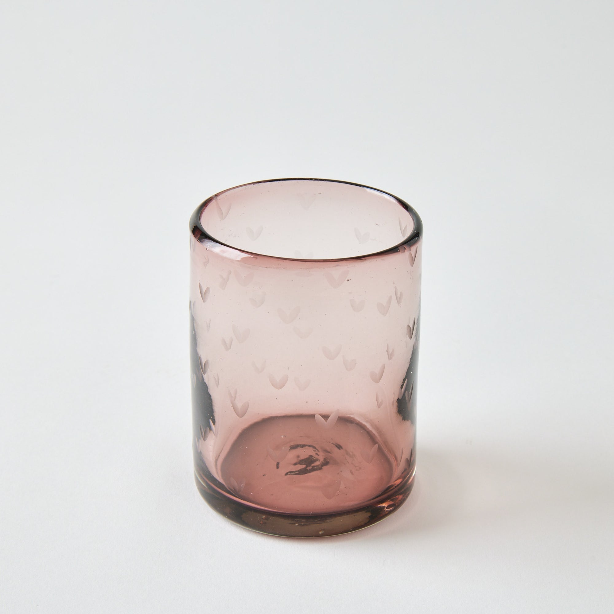 Pink glass with textured surface on a white background