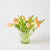 Clear glass vase with peach-colored tulips on a light background