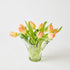 Clear glass vase with peach-colored tulips on a light background